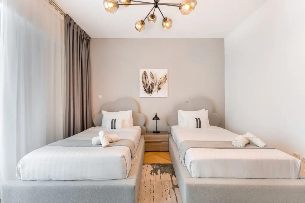 Chambre avec deux lits et table de chevet au centre