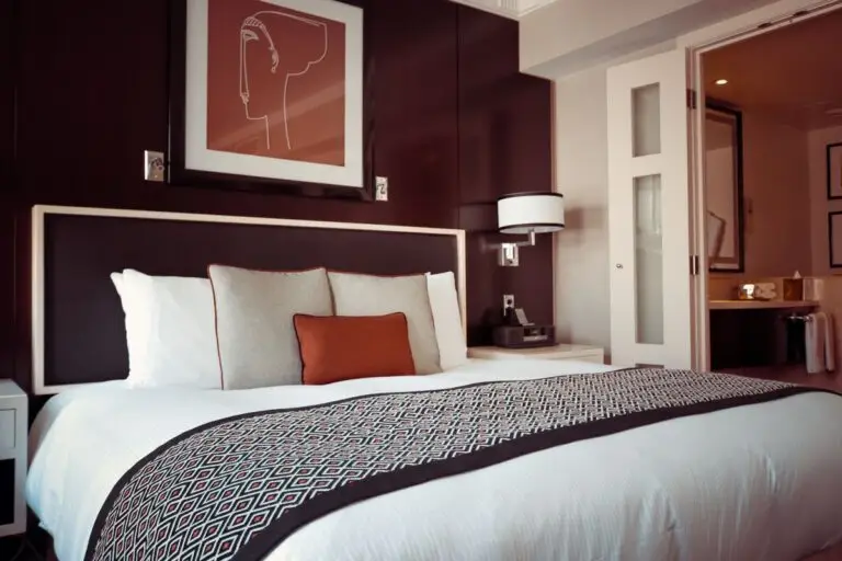 Large bed with white sheets in a room with dark walls