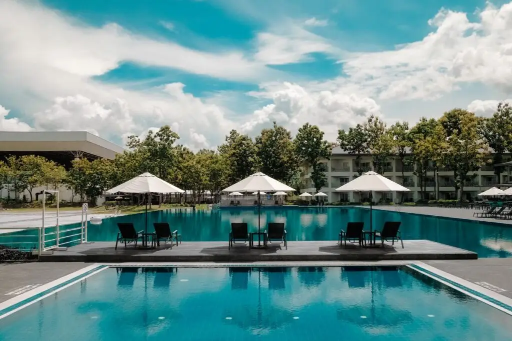 Piscine extérieure bordée de chaises longues sous un ciel bleu