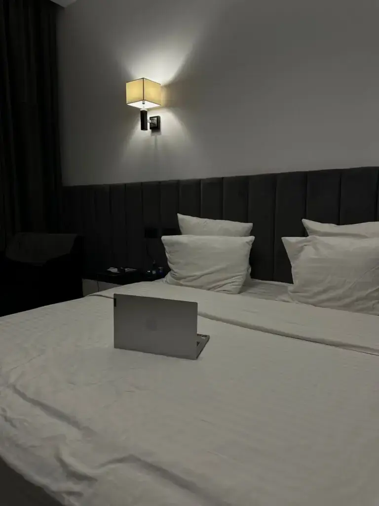 Ordinateur portable posé sur un lit de chambre d’hôtel
